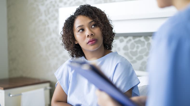 Young patient looking at doctor in hospital ward