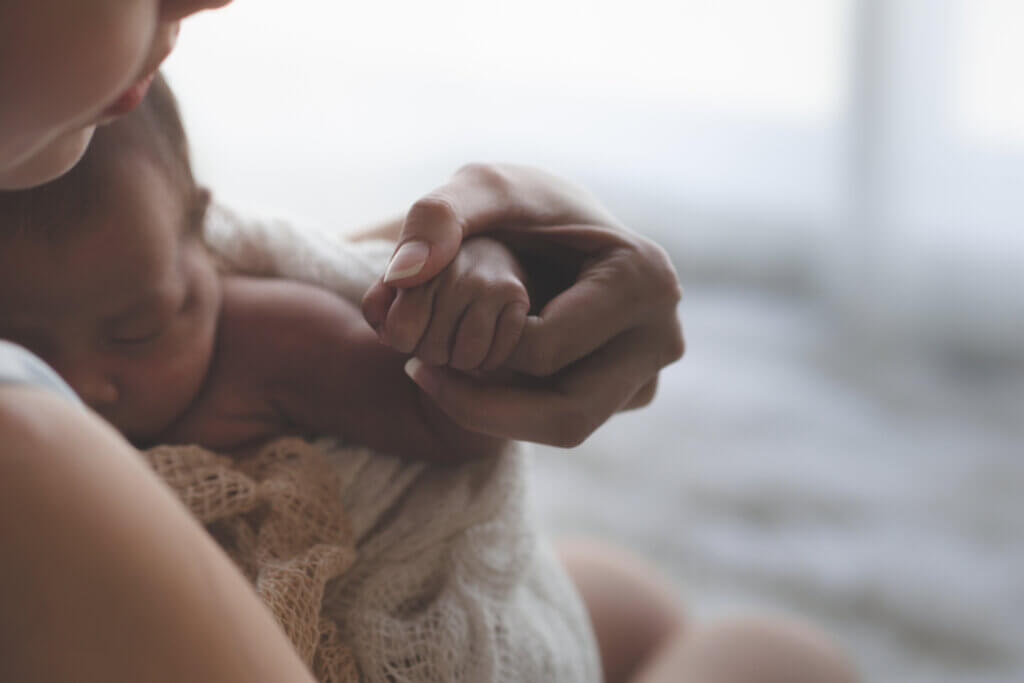 Mother holding infant's hand