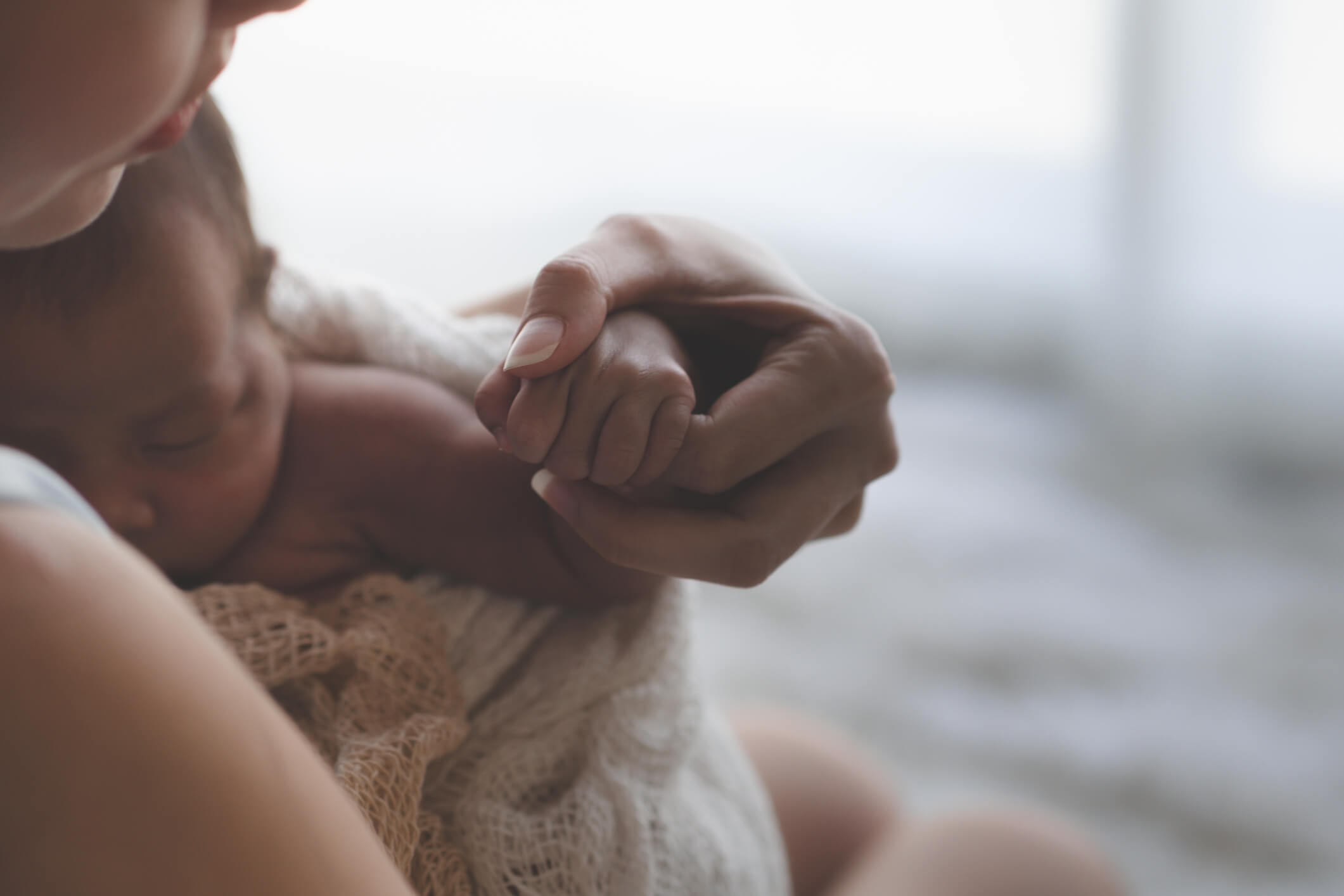 Mother holding infant's hand